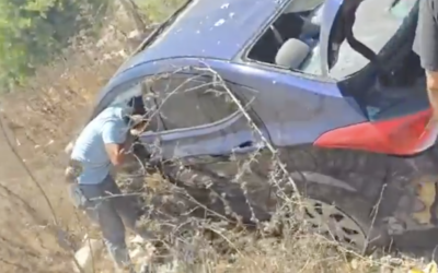 People inspect a bombed-out car, reportedly after it was struck by the IDF in a targeted strike on a senior Hezbollah operative in south Lebanon's Sir El Gharbiyeh, August 29, 2025. (Muntasser Abdallah/L'Orient Today via X)